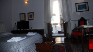 Hotelkamer met een bed, een televisie, een bureau met stoel en uitzicht.