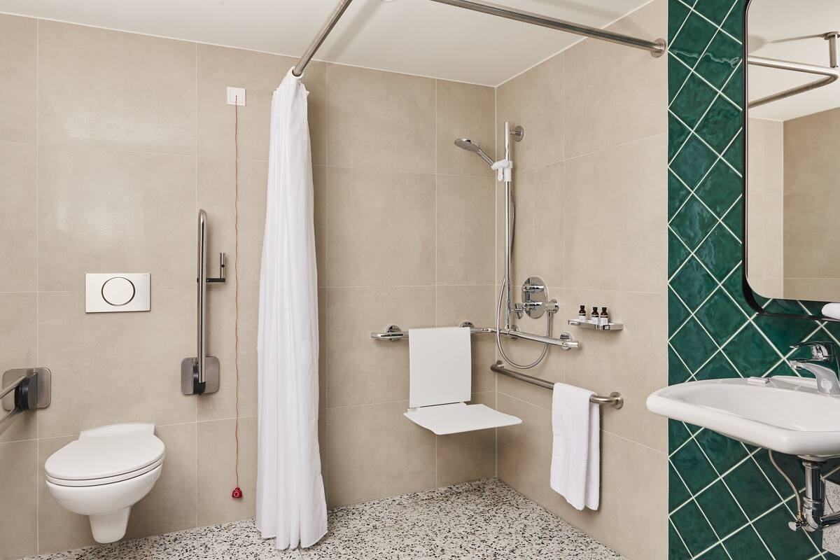 A modern bathroom with a shower, toilet, and sink.