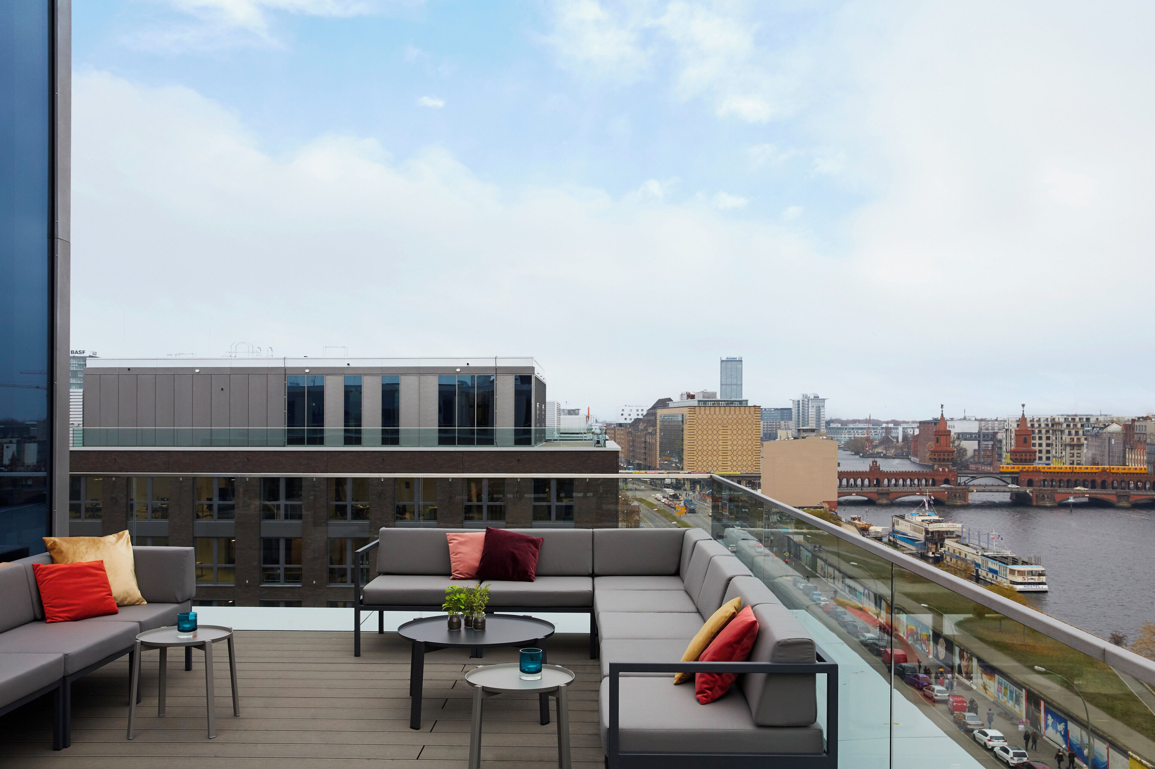 A modern outdoor seating area with a view of a river and cityscape.