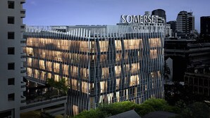 Een modern gebouw met een unieke gevel, waarop de naam “SOMERSET” duidelijk zichtbaar is.