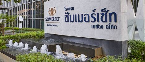 A sign with the name 'Somerset' and Thai script, indicating a hotel or establishment.