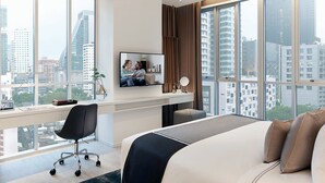 Een moderne hotelkamer met een groot bed, een bureau met een computer en een televisie.