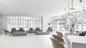 Een ruime woonkamer met een grote hoekbank, een salontafel en een moderne kroonluchter.