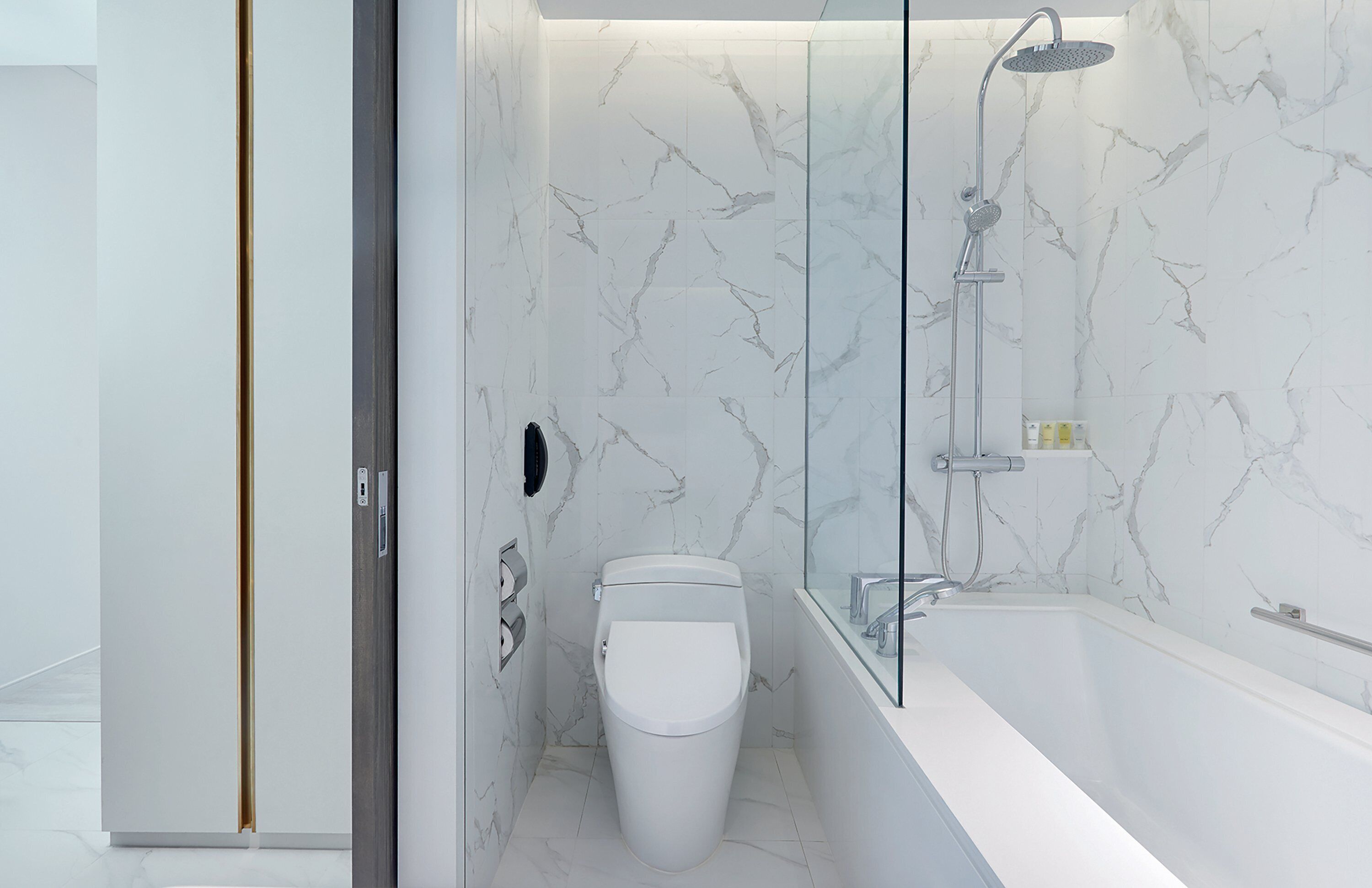 A modern bathroom with a toilet, a glass-enclosed shower, and a bathtub.