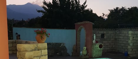 A swimming pool with a stone wall and a tiled deck.
