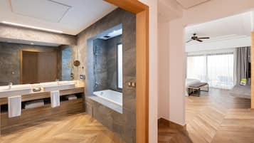 Ein modernes Badezimmer mit einem großen Spiegel, zwei Waschbecken und einer Badewanne.