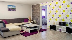 A modern living room with a grey sofa, white coffee table, and purple accents.