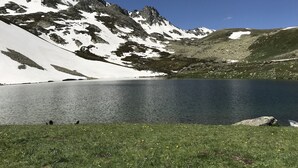 A mountain lake with snow-capped peaks and a grassy foreground. - Yedigoller Hotel & Restaurant (Çaykara)