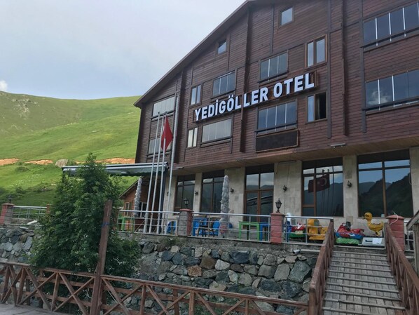 A hotel named "Yedigöller Otel" with a stone wall and a staircase leading to the entrance. - Yedigoller Hotel & Restaurant (Çaykara)