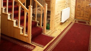 A wooden interior with a staircase leading to a second floor, a radiator, and a door. - Yedigoller Hotel & Restaurant (Çaykara)