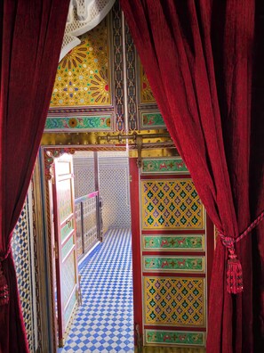 A corridor with ornate tile patterns and a checkered floor.