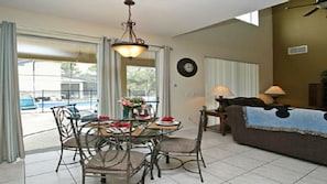 Un coin repas avec une table et des chaises, un canapé et une lampe.
