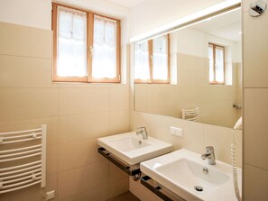 A bathroom with two sinks, a mirror, and a towel rack. - Lovely apartment for 4 guests with WIFI, TV, terrace and panoramic view (Donnersbach)