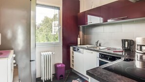 Eine moderne Küche mit Einbauofen, Kaffeemaschine und einem Fenster mit Blick auf Grünflächen.