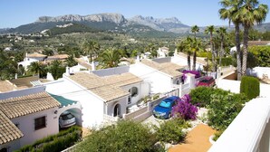 A residential area with white buildings, a blue car, and palm trees. - Nice apartment in villa for 6 people with WIFI, pool, TV and terrace (Benissa)