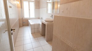 Un baño con bañera, lavabo y tocador.
