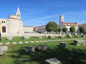A historical square with ancient stone slabs, a church with a bell tower, and a large tree in the center. - Stunning  villa for 8 guests with WIFI, A/C, private pool, TV, terrace and pets allowed (Zadar)