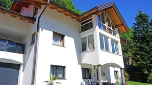 A two-story building with a white facade, large windows, and a balcony with outdoor seating. - Nice apartment for 4 people with WIFI, TV, patio and pets allowed (Wenns)