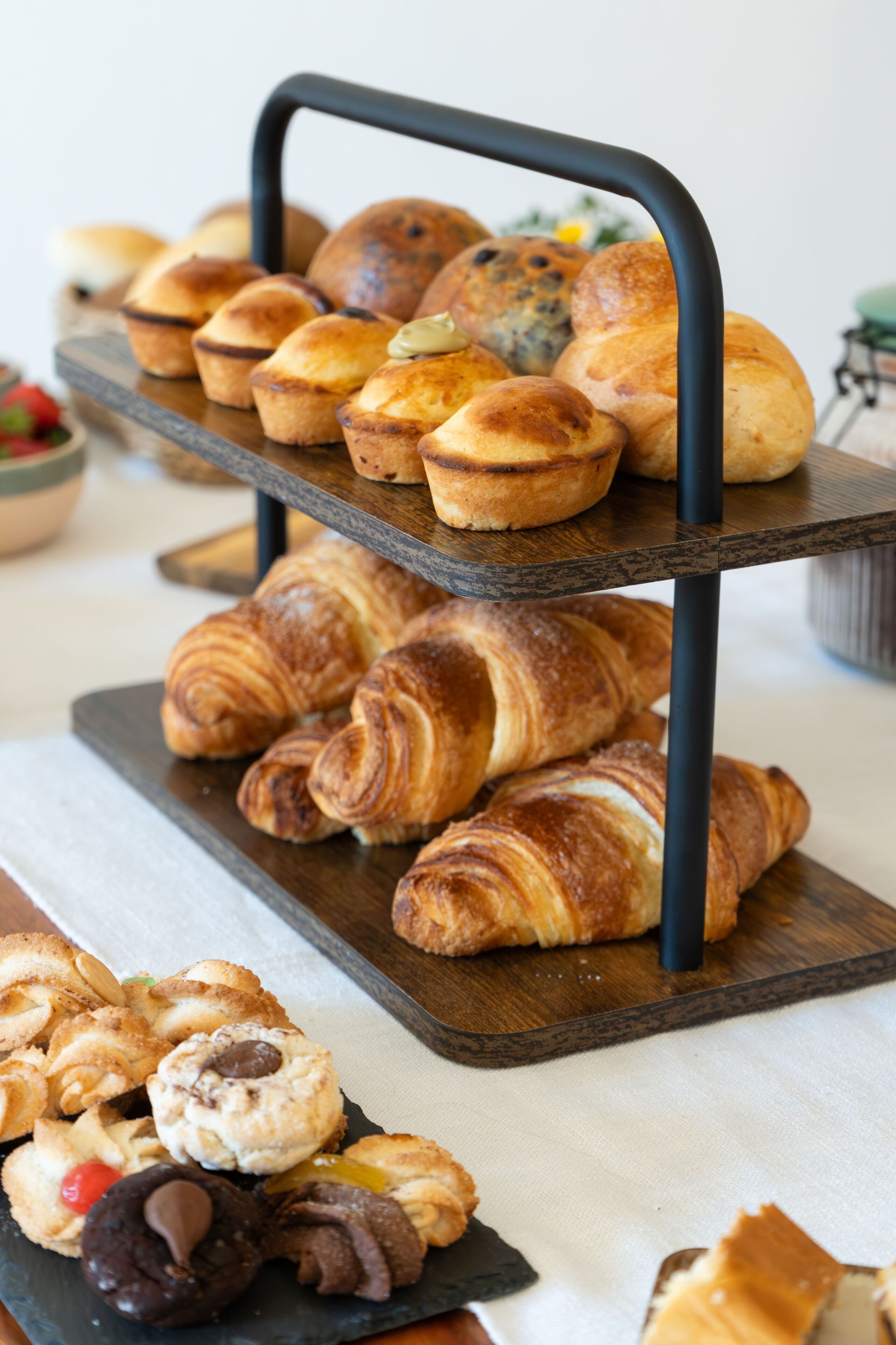 A tiered serving tray with assorted pastries and cookies.