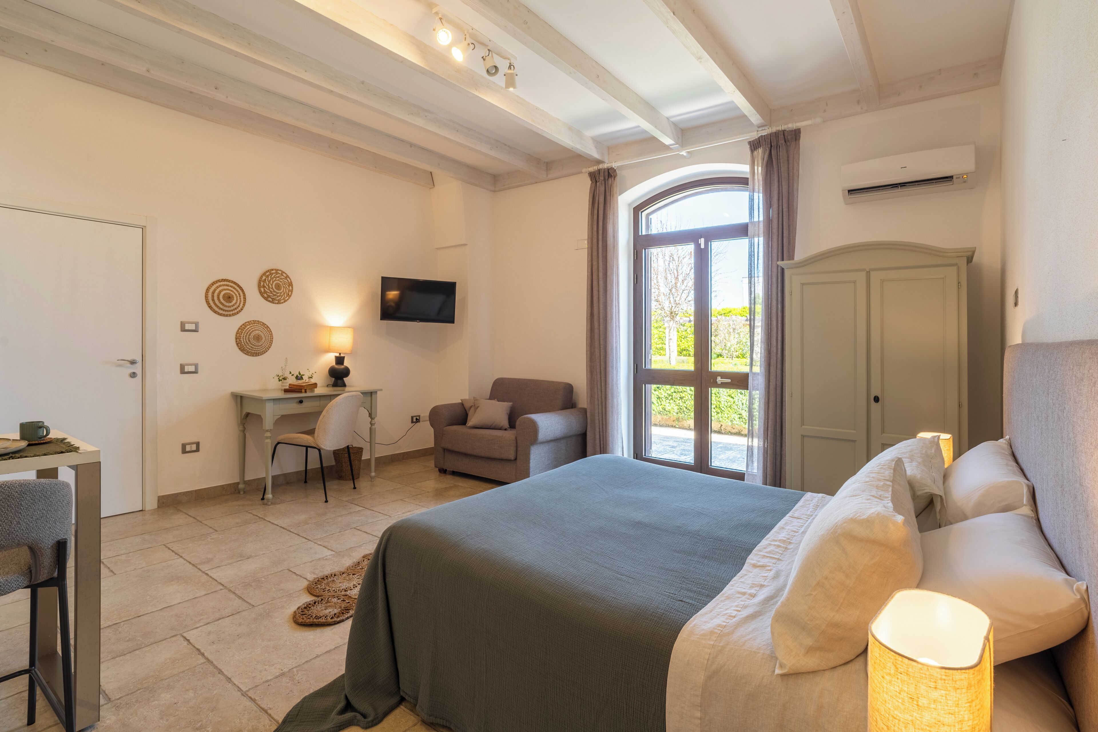 Ein Schlafzimmer mit Bett, Schreibtisch, Stuhl und Fernseher.