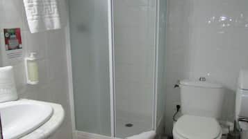 A bathroom with a shower, toilet, and sink.