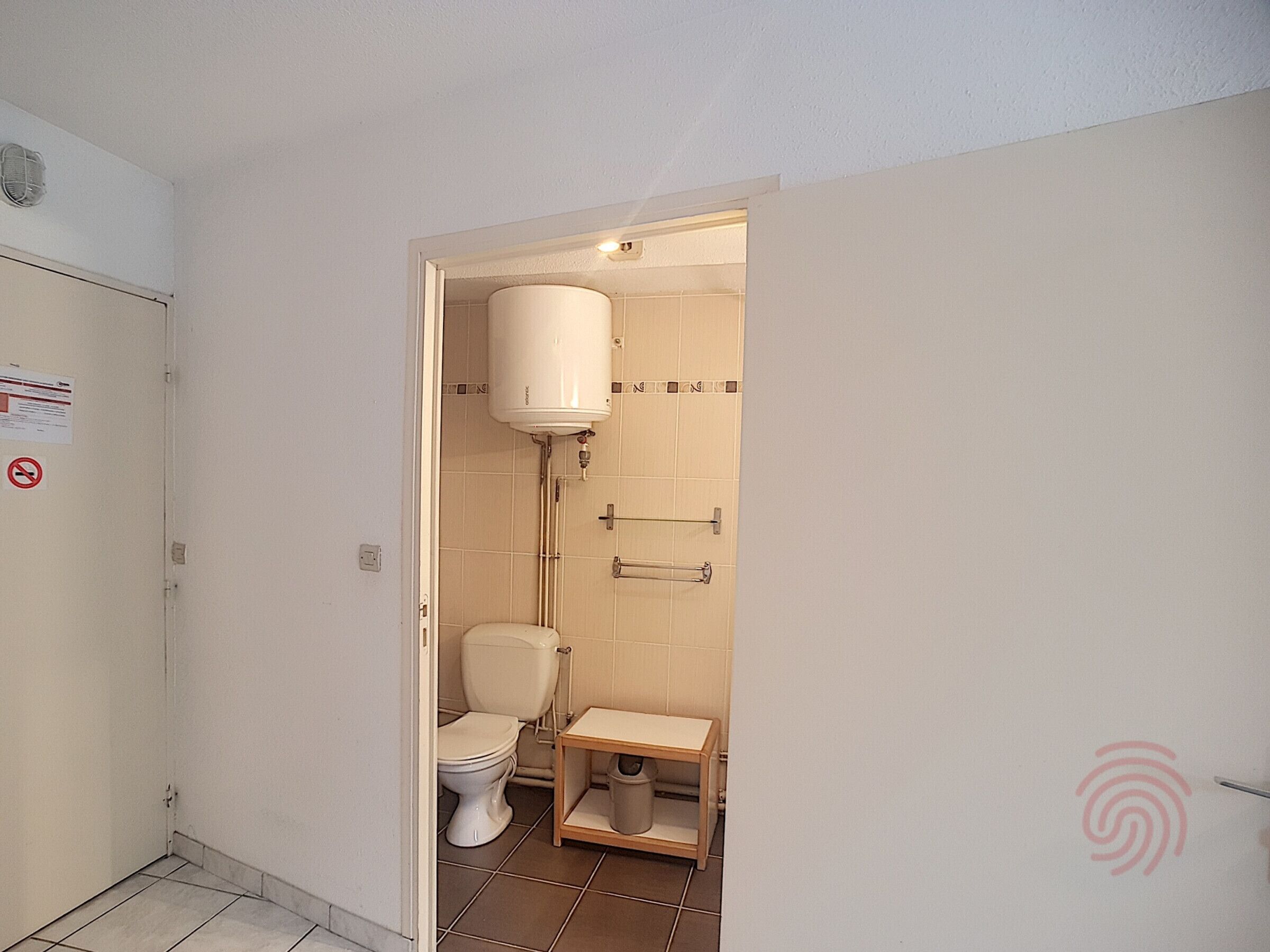A small bathroom with a toilet, a sink, and a shower.