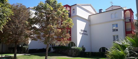 Un edificio con un cartel que dice "RESIDENCE PLEIN SOLEIL", indicando una propiedad residencial.