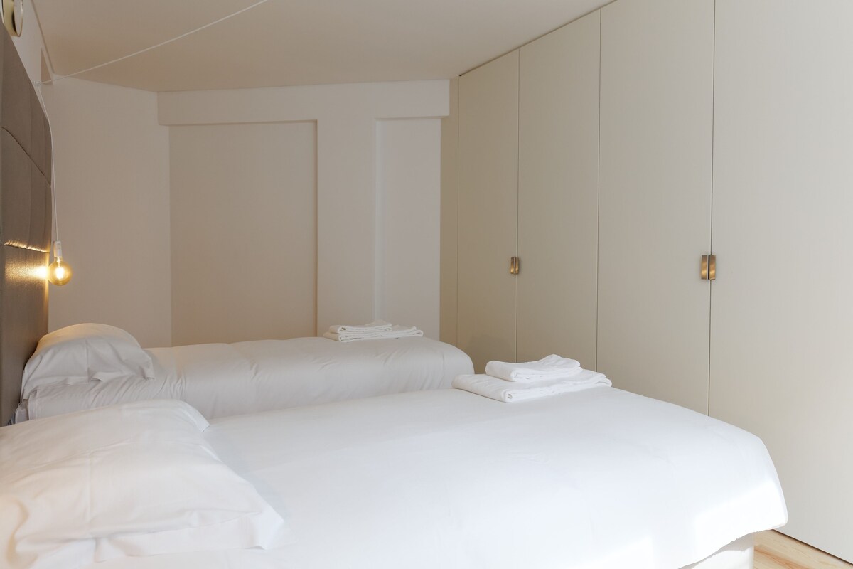 A hotel room with a bed, a nightstand, and a wardrobe.