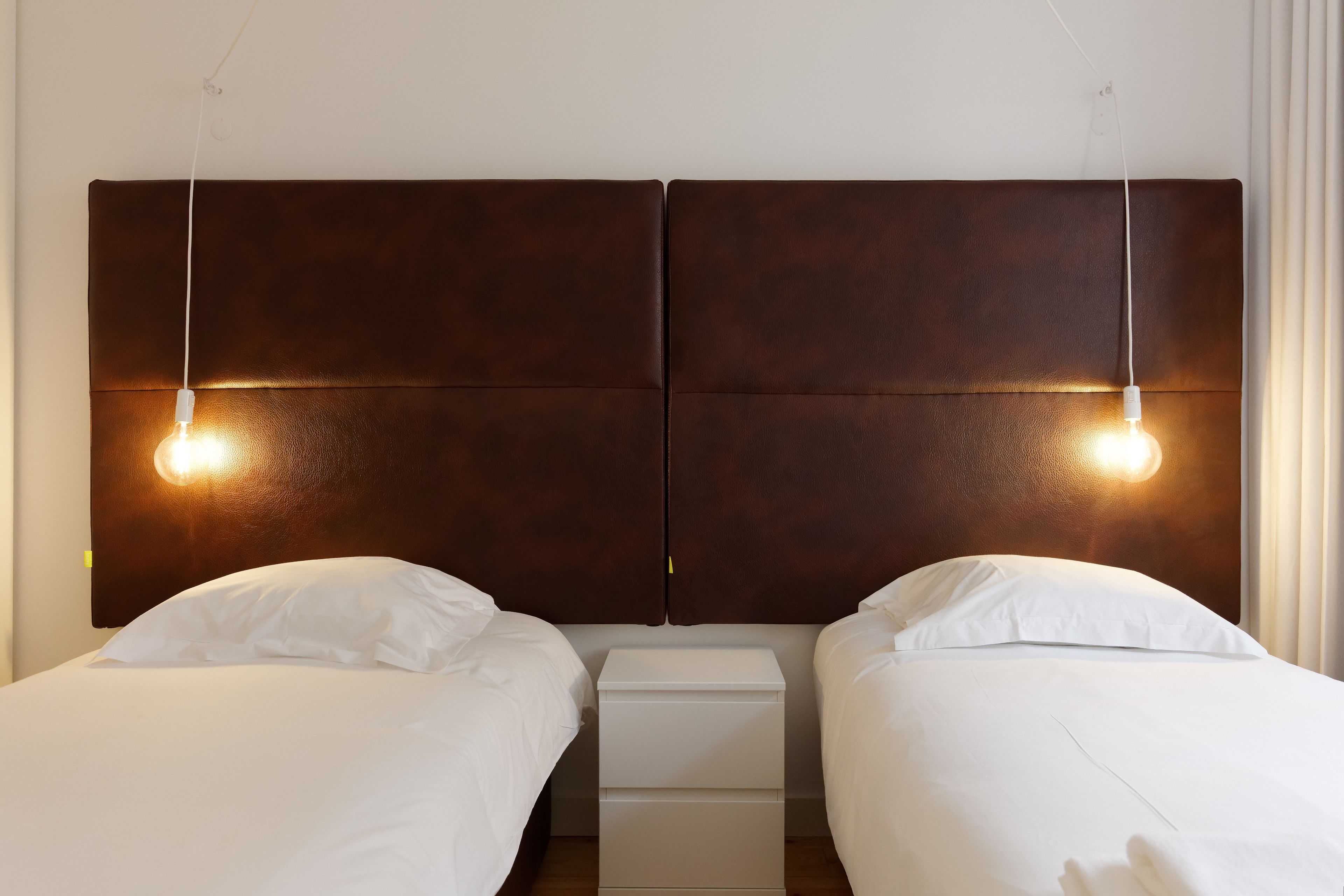 A double bed with a wooden headboard, two bedside tables, and a nightstand.