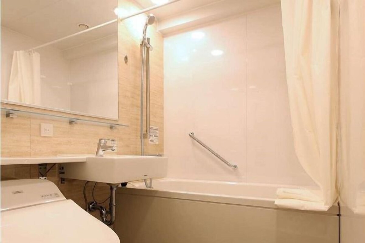 A bathroom with a bathtub, a sink, and a mirror.
