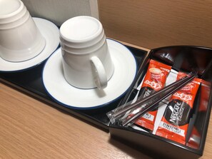 A tray with two white cups and saucers, and a box containing red and white Nescafé coffee packets. - Kobe Luminous Hotel Sannomiya (Kobe)