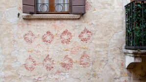 A building facade with a window, a balcony with a metal railing, and a patterned wall. - B&B Barberia (Treviso)
