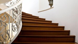 A spiral staircase with ornate metal railings and a wall-mounted light fixture. - B&B Barberia (Treviso)