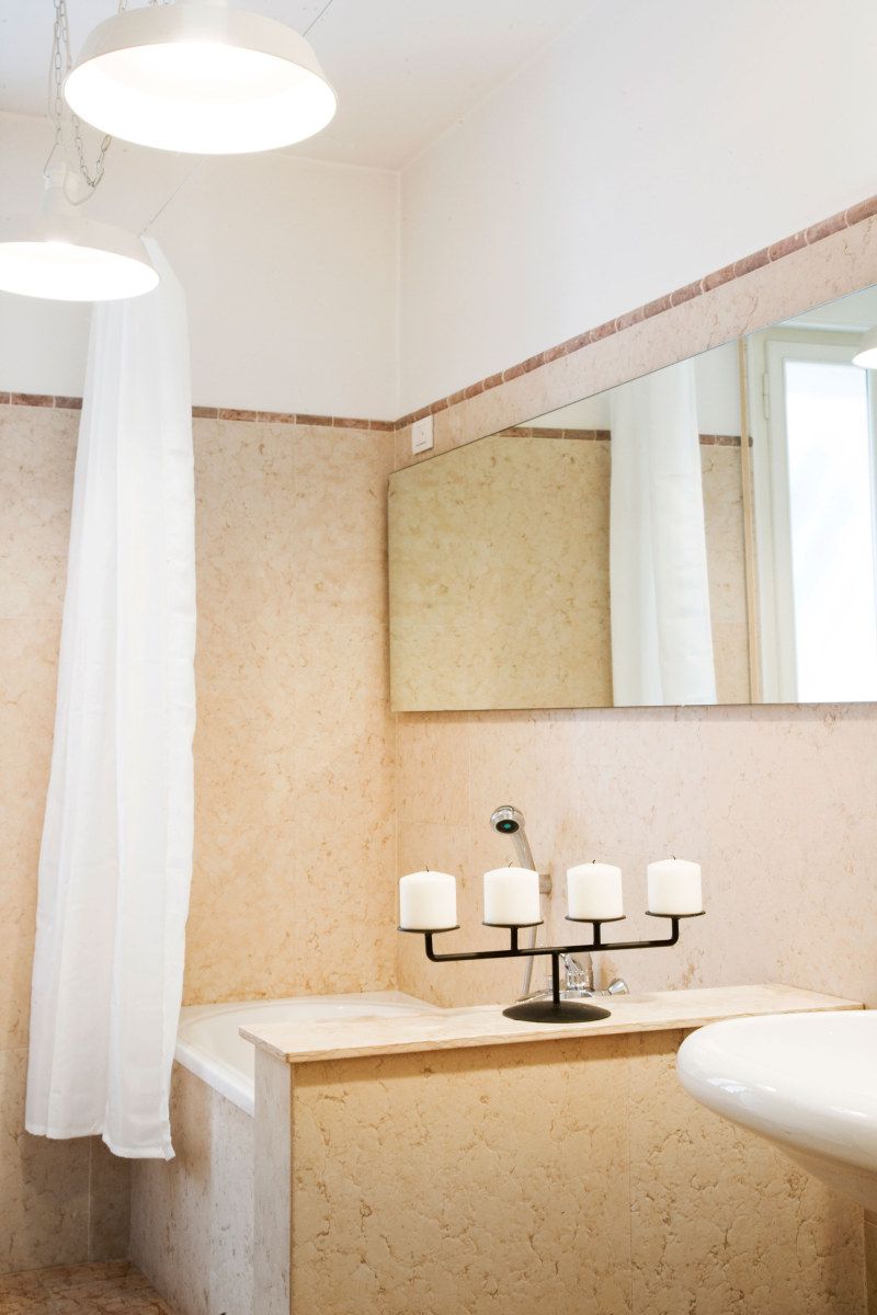 Un bagno con una vasca, un lavandino, uno specchio e una tenda da doccia.