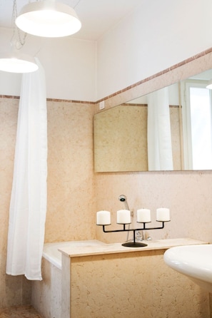 A bathroom with a bathtub, a sink, a mirror, and a shower curtain. - B&B Barberia (Treviso)
