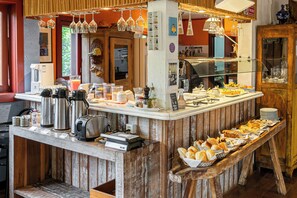 A buffet setup with various food items, a coffee station, and a cash register. - Pousada Casa da Lagoa (Florianópolis)