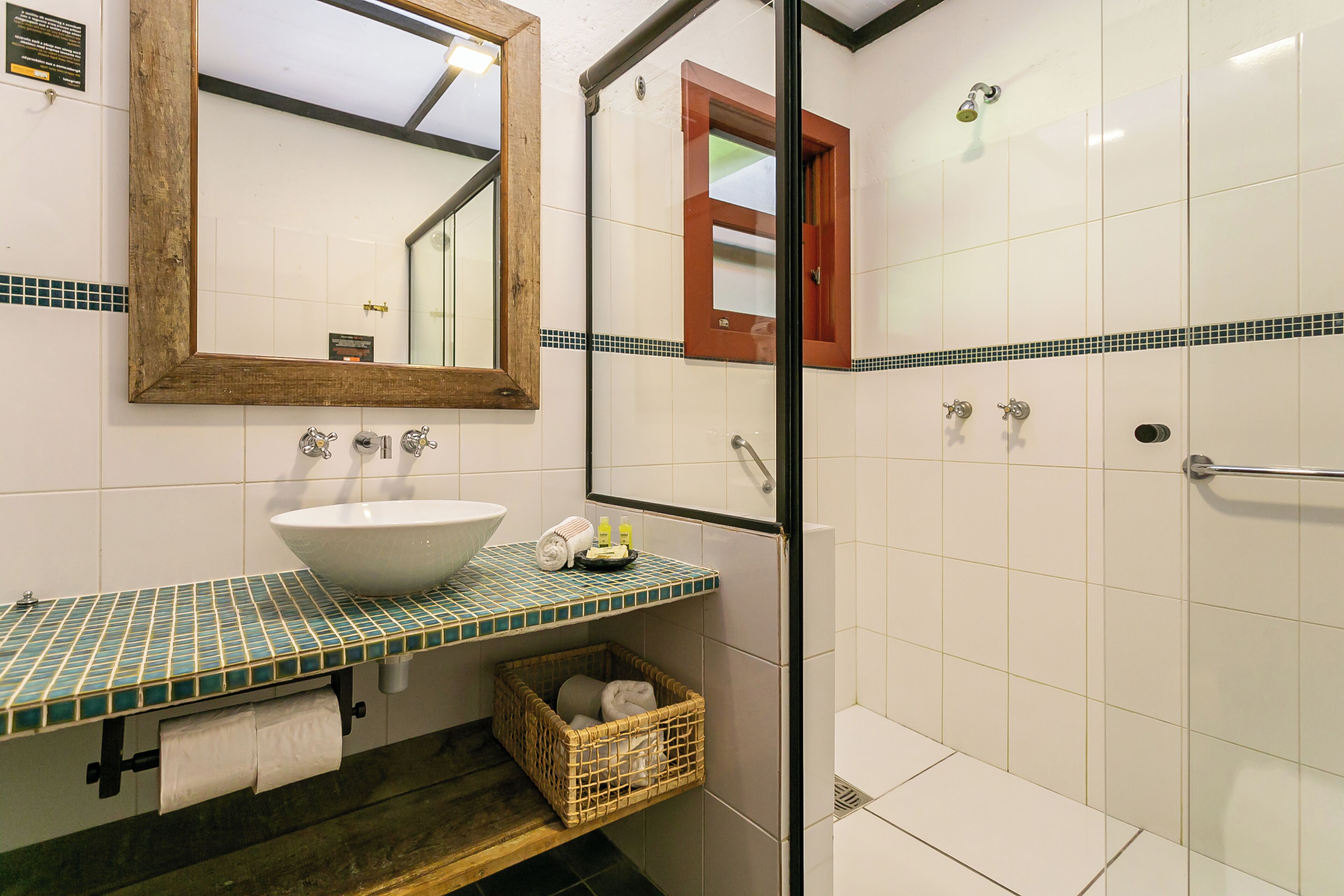 A bathroom with a white sink, a mirror, and a shower.