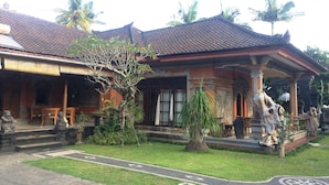 A traditional building with a tiled roof, a front porch, and a garden with a pathway. - Puri Sangkih (Munduk)