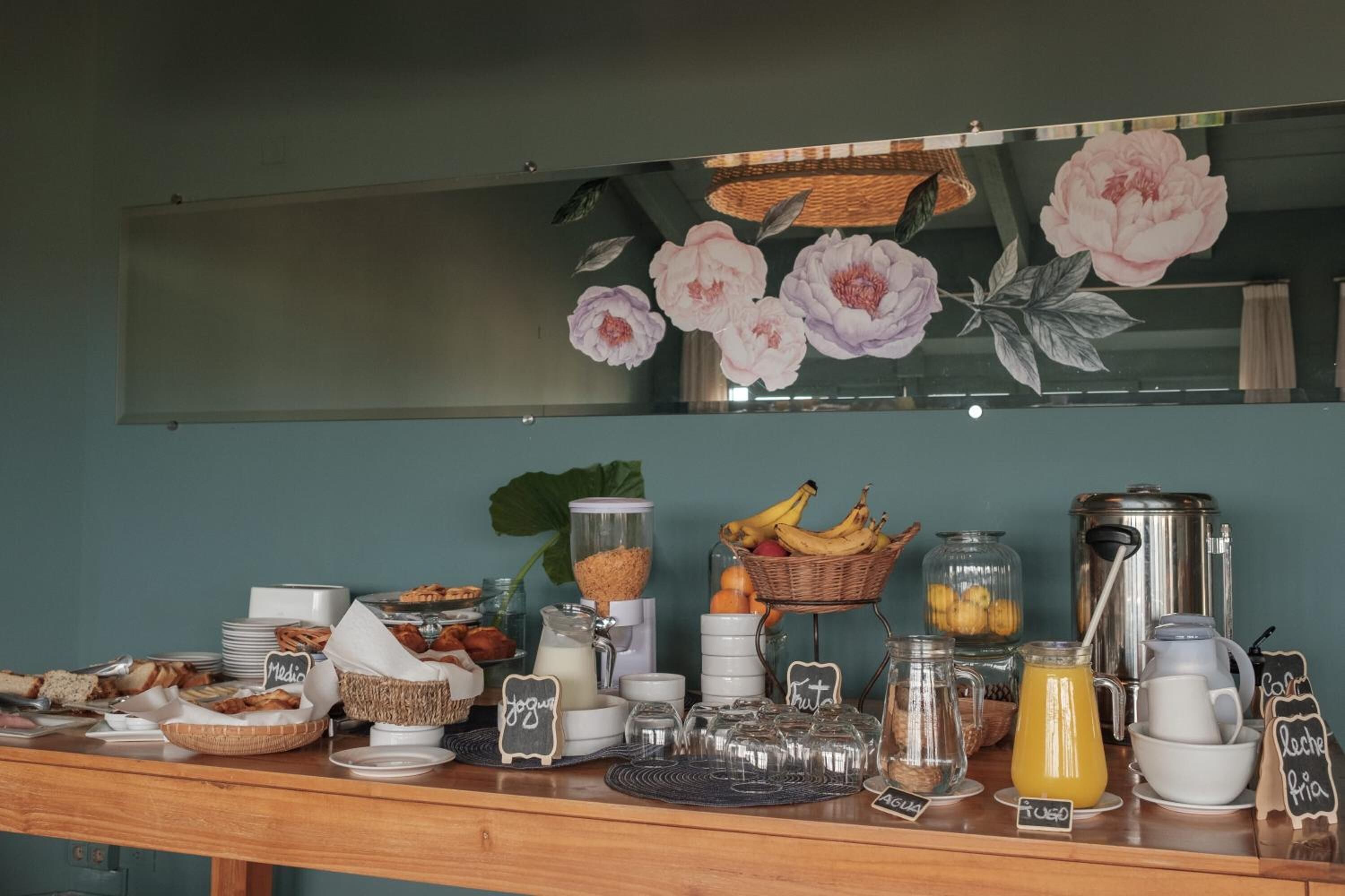A breakfast buffet with various food items and beverages, including yogurt, fruit, and coffee.