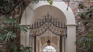 Una entrada empedrada con una reja de hierro que da a un pasillo.