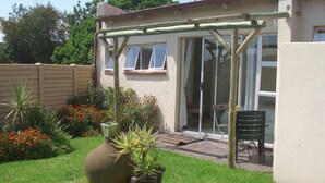 A house with a patio, a large vase, and potted plants. - Gold Reef Place (Johannesburg South)