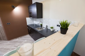 Enjoy cooking in this well-equipped kitchen with a sleek countertop, wooden island, and compact dishwasher.