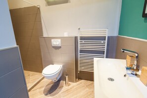 Enjoy a clean and neutral bathroom with a sleek toilet, spacious sink, and towel rack.