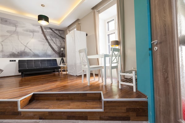 Relax in this stylish room with a sofa, dining table, and cabinet.