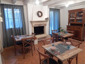 A dining area with a fireplace, wooden furniture, and a cabinet.