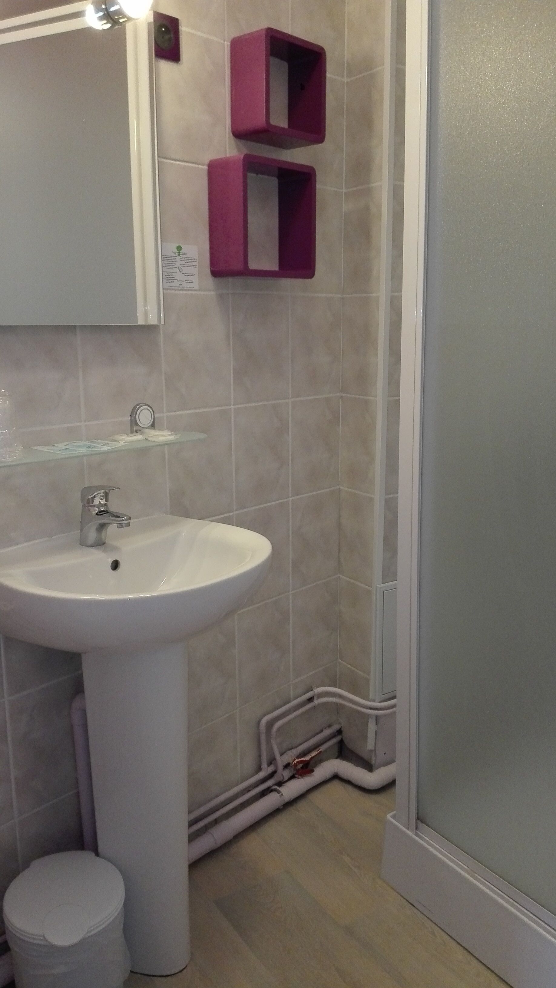 A bathroom with a white sink, a mirror, and a shower area.