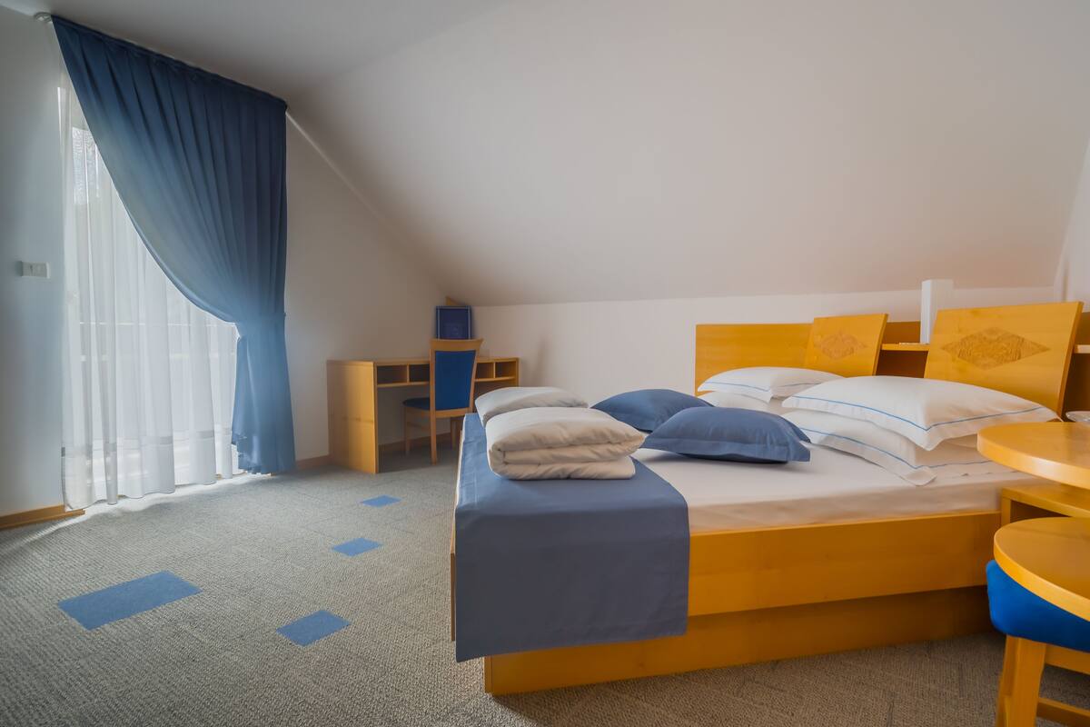A hotel room with a bed, a desk, and a chair.