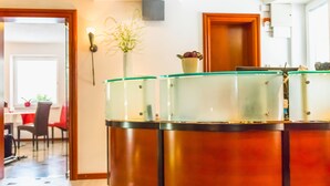 A modern kitchen with a central island, a dining area with chairs, and a plant on the wall. - Villa Nena (Kranjska Gora)