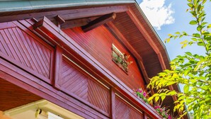 A two-story building with a balcony, wooden furniture, and potted plants. - Villa Nena (Kranjska Gora)