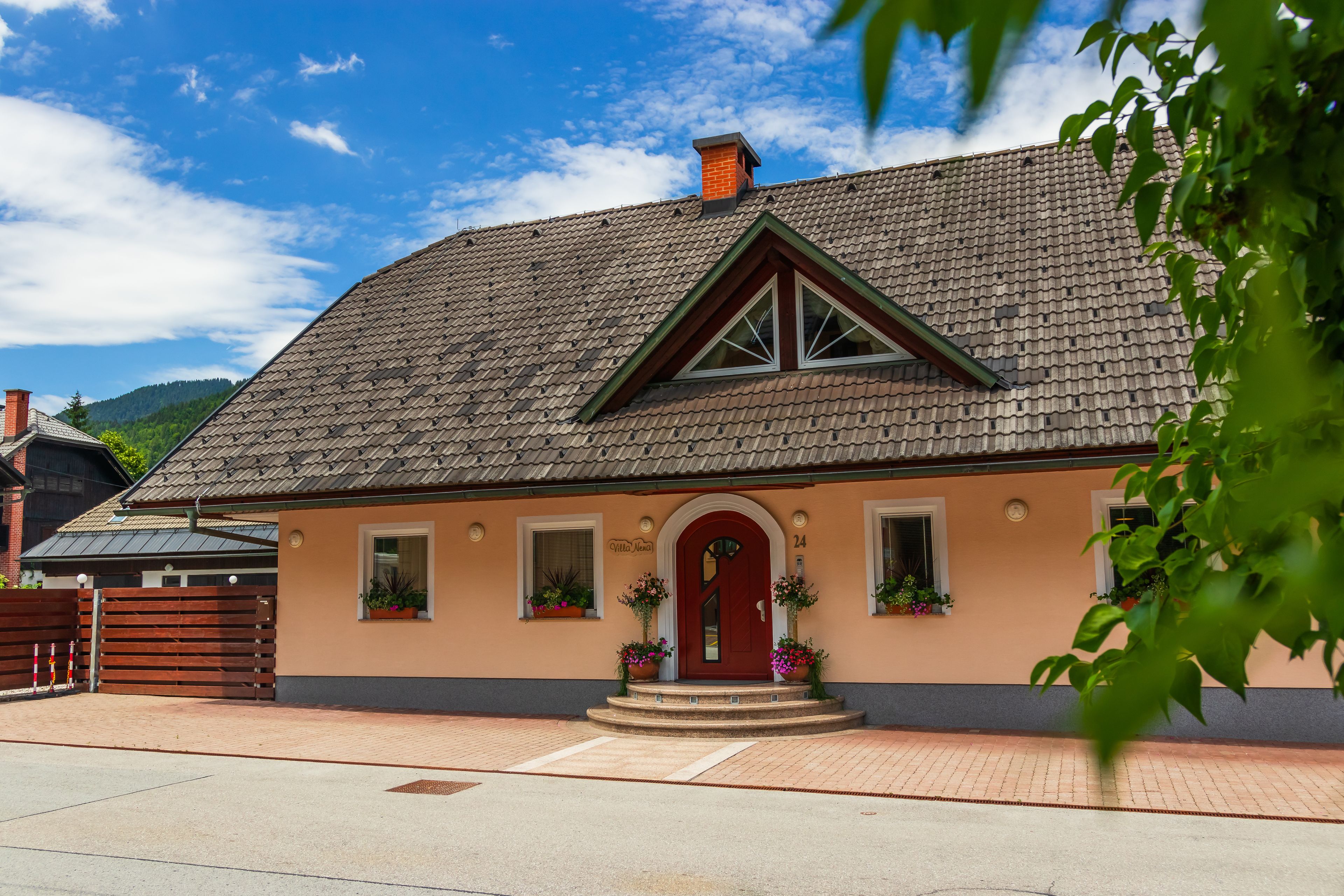 A house with a red door, a small porch, and flower boxes.